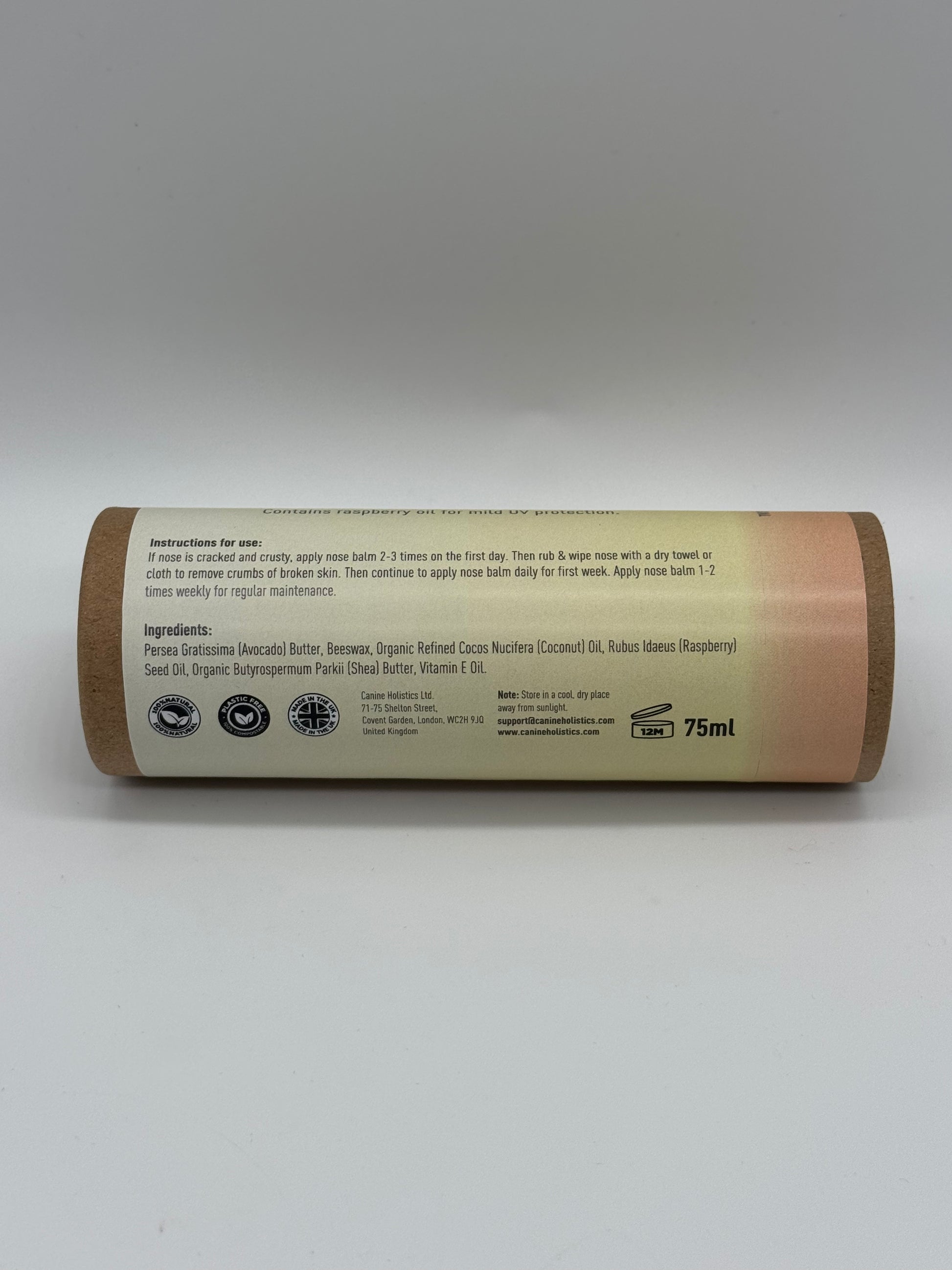 Image containing Canine Holistics™ Natural Nose Balm for Dogs 100ml. Rear view of branded product in biodegradable tube laying on its side, displaying product ingredients and instructions for use. 