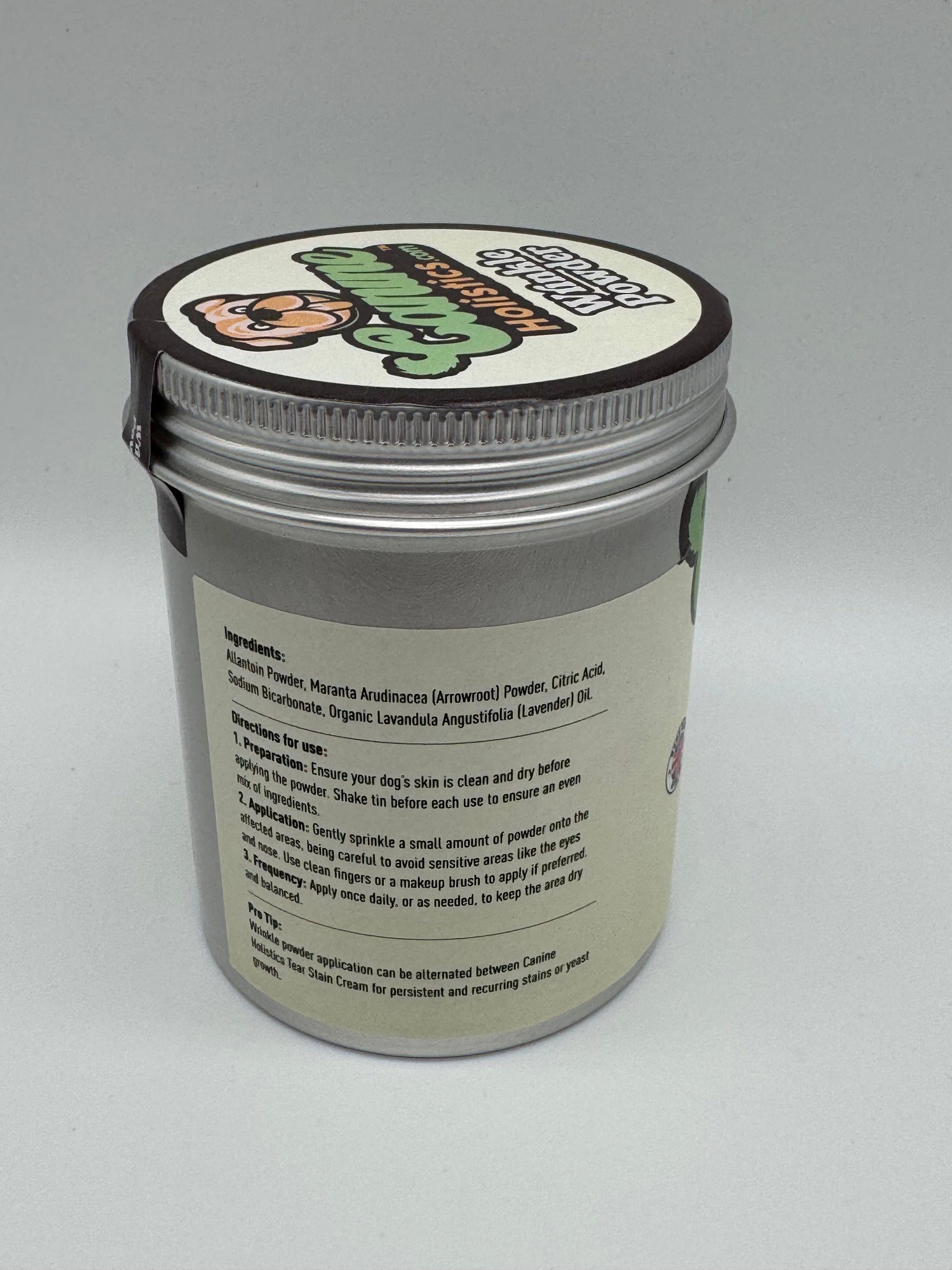 Image containing Canine Holistics™ Wrinkle Powder 250g. Left side view of branded product in aluminium packaging tin, displaying instructions for use and list of ingredients. 